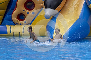 Children play and swim in pool. Two children are having fun in pool. Friends splashing in pool having fun leisure time. Summer