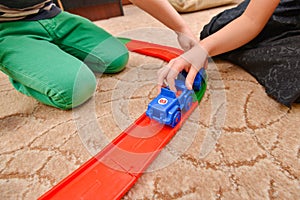 Children play in toy cars on a toy road in a children`s room