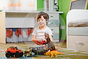 Children play with a toy designer on the floor of the children's room. Boy playing with colorful blocks