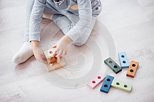 Children play with a toy designer on the floor of the children`s room. Two kids playing with colorful blocks