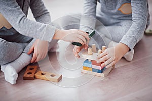 Children play with a toy designer on the floor of the children`s room. Two kids playing with colorful blocks