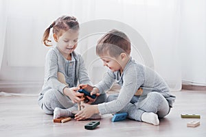 Children play with a toy designer on the floor of the children`s room. Two kids playing with colorful blocks