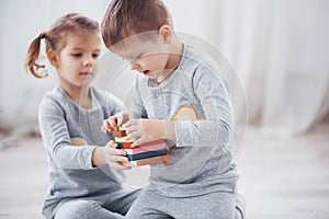 Children play with a toy designer on the floor of the children`s room. Two kids playing with colorful blocks