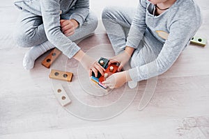 Children play with a toy designer on the floor of the children`s room. Two kids playing with colorful blocks