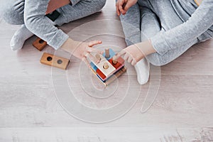 Children play with a toy designer on the floor of the children`s room. Two kids playing with colorful blocks