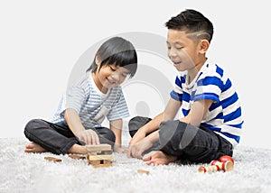 Children play with a toy designer on the floor of the children`s room. Two kids playing with colorful blocks.