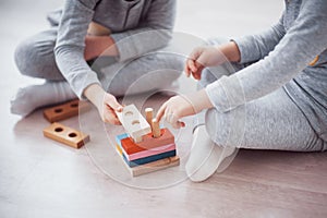 Children play with a toy designer on the floor of the children`s room. Two kids playing with colorful blocks