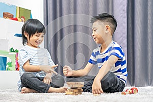 Children play with a toy designer on the floor of the children`s room. Two kids playing with colorful blocks. Kindergarten educati