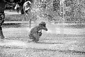 Children play with water in a fountain