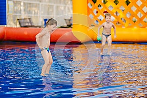 Children play in the water pool. Two boys playing with ball in an inflatable pool
