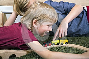 Brothers play with wooden train, build toy railroad at home or d