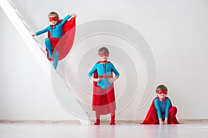 Children playing as superheroes with red coats