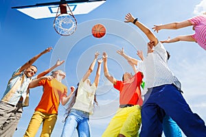 Children playing basketball with a ball up in sky