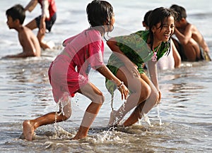CHILDREN PLAYING AT THE BEACH IN INDONESIA