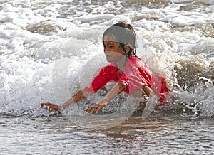 CHILDREN PLAYING AT THE BEACH IN INDONESIA