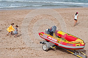 Children playing on the beach near a surf rescue boat in Umhlanga Rocks