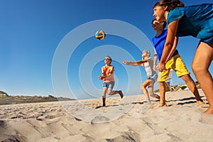 Children playing beach volleyball during vacation on the sea