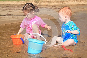 Children playing in beach water with kids toys