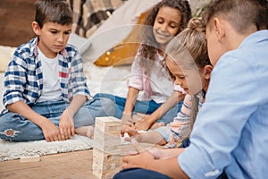 Children playing blocks wood game together at home