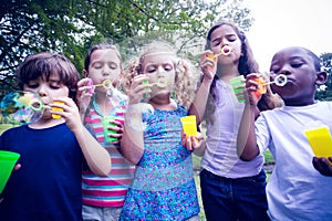 Children playing with bubble wand in the park