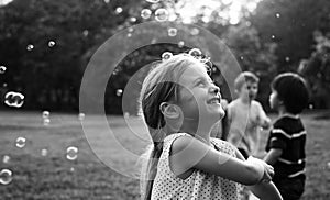 Children is playing bubbles in a park