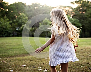 Children is playing bubbles in a park