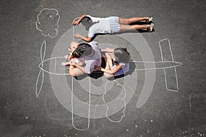 Children playing in a chalk airplane