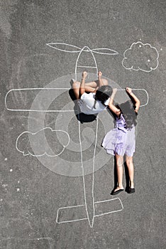 Children playing in a chalk airplane