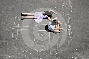 Children playing in a chalk airplane