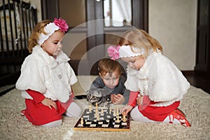 Children playing chess lying on floor