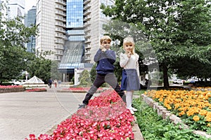 Children playing in the city park looking at flowers with a magnifying glass