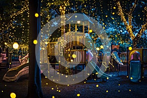 Children playing in a designated area as fireflies illuminate the sky above them, An enchanting playground illuminated by