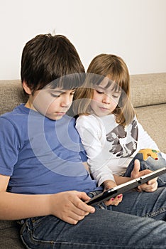 Children playing with a digital tablet photo