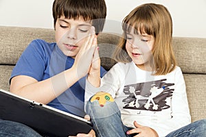 Children playing with a digital tablet photo