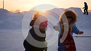 Children playing with a dog in winter at sunset