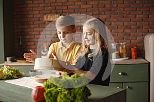 Children playing with a flour in a kitchen