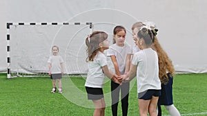 Children playing football indoors. Kids doing a team support. Hand on hand team gesture