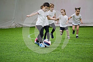 Children playing football indoors. Kids running on the field. A little boy is ready to kick the ball