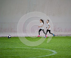 Children playing football indoors. A little girl and boy playing