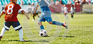 Children playing the game on football soccer stadium field. Boys compete during a soccer tournament match