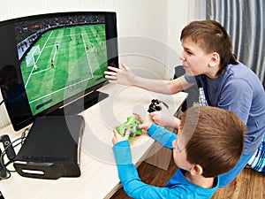 Children playing on games console to play football