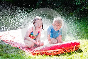 Children playing with garden water slide