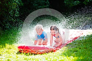 Children playing with garden water slide