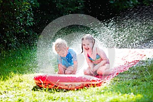 Children playing with garden water slide