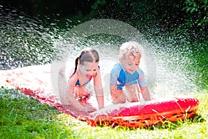 Children playing with garden water slide