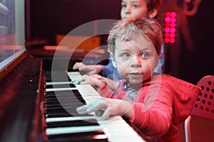 Children playing on light music piano