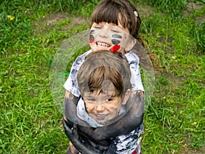 Children playing in mud, dirty cloth, messy face and hands in mud. Stains on clothes.