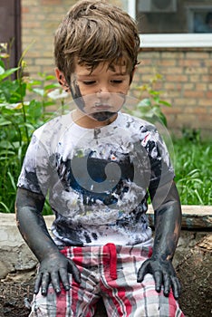 Children playing in mud, dirty cloth, messy face and hands in mud. Stains on clothes.