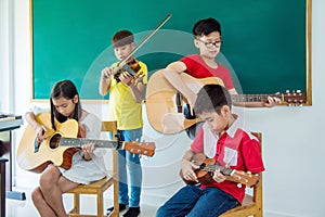 Children playing music instruments in music classroom