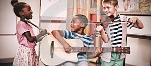 Children playing musical instruments in classroom